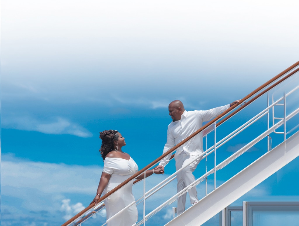 a married couple holds hands while walking up the stairs