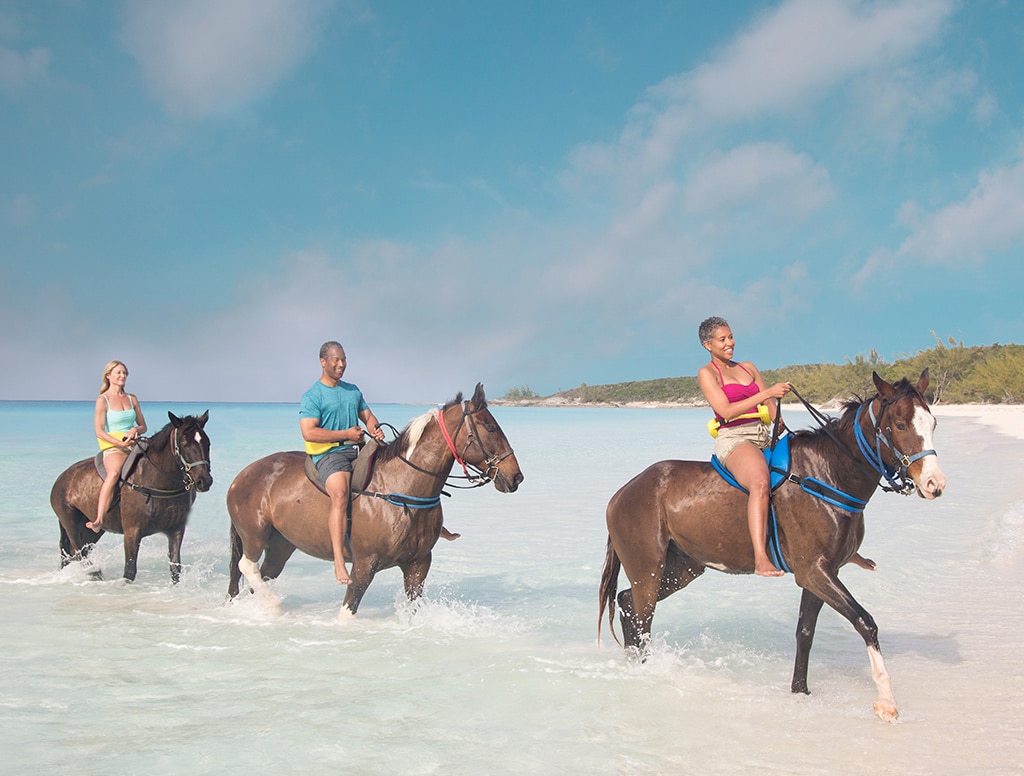 guests enjoying a horseback ride through the shore of half moon cay