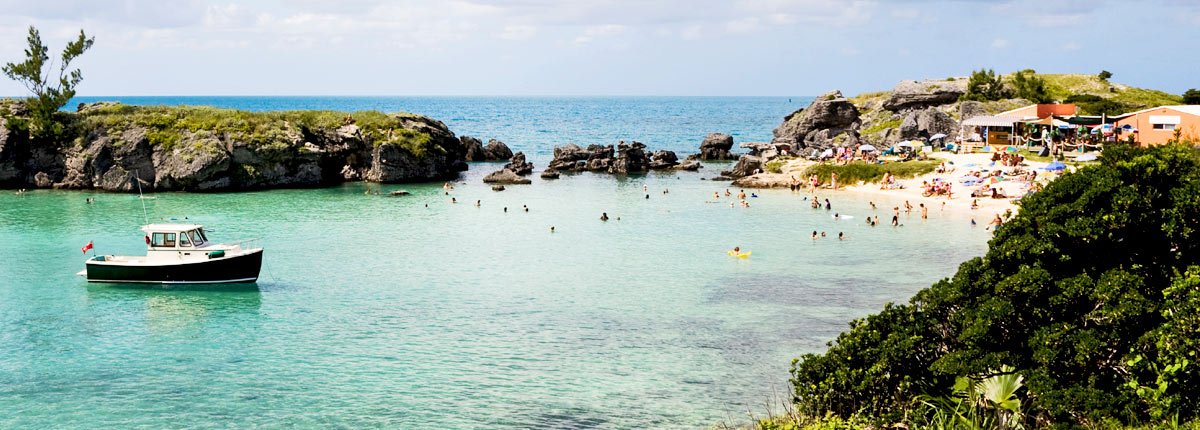 a boat anchored off of a beach in Bermuda