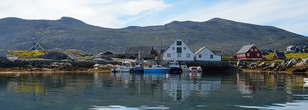 colorful houses and boats on a lake in nanortalik, greenland