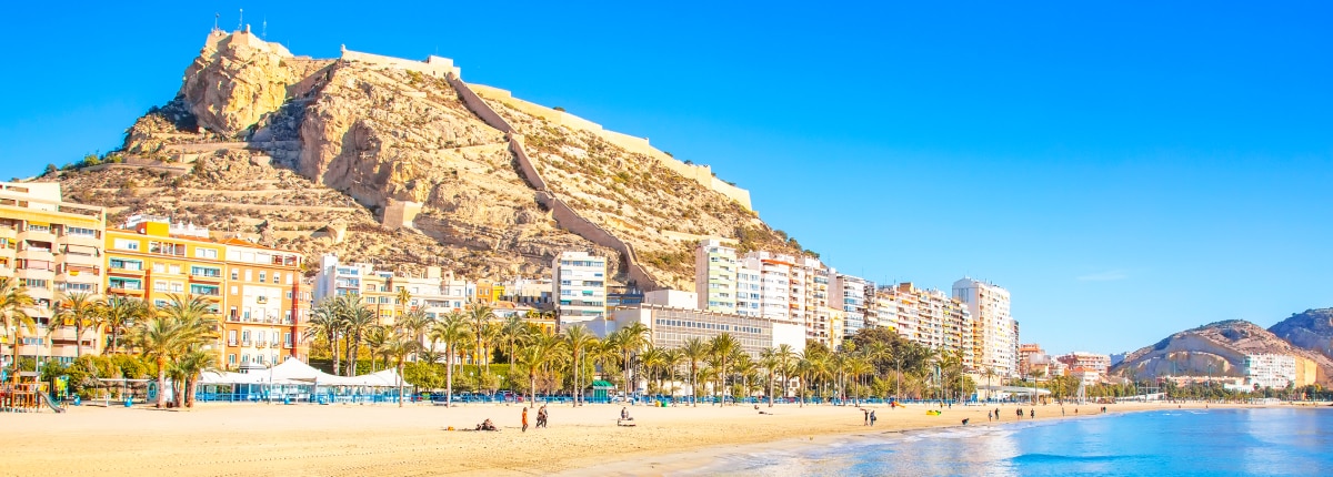 large mountain looming over a coastal beach 