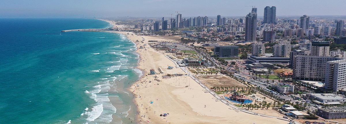 the skyline is full of skyscrapers near a golden sandy beach