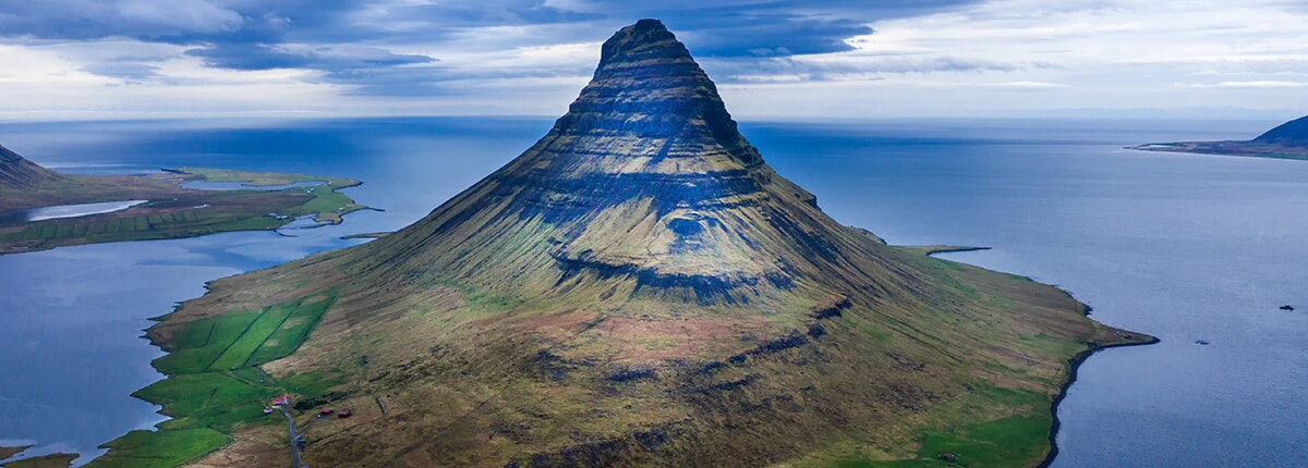 mount kirkjufell surrounded by water in grundarfjordur, iceland