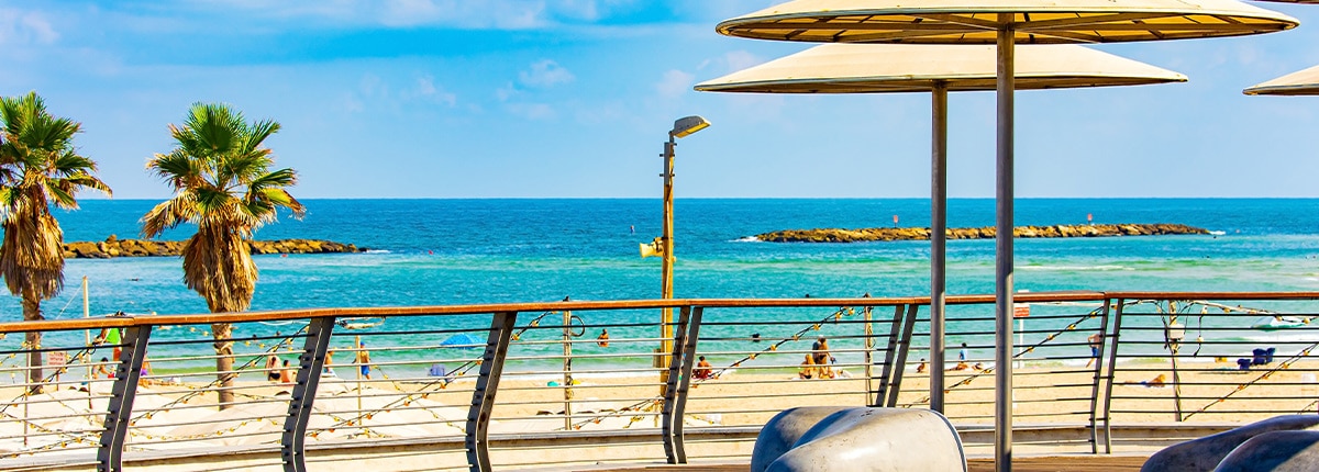 several umbrellas are on a large deck on a golden sand beach