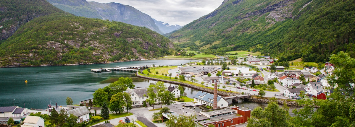 a small town surrounded by a fjord, mountains and lush trees