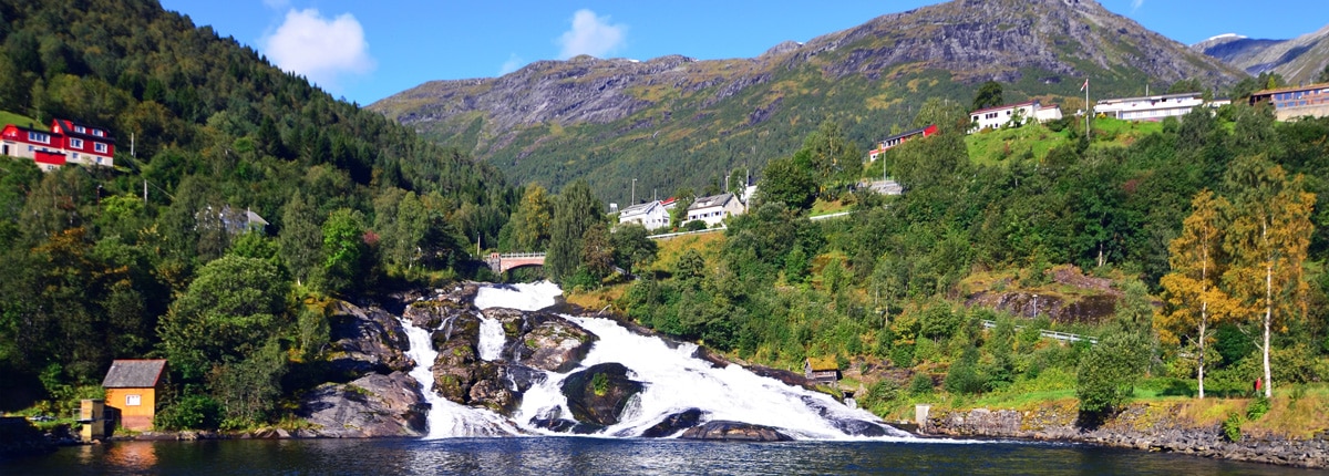 picturesque homes on the mountainside alongside a waterfall