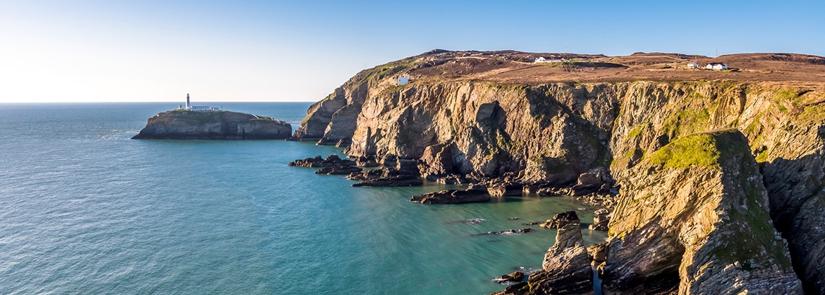 cliffside view of the ocean and the stack lighthouse