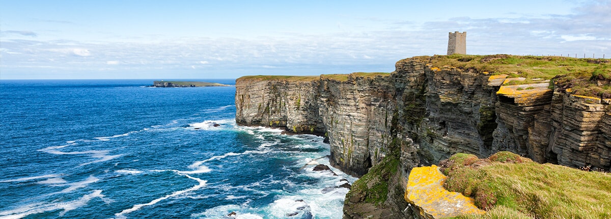 fort overlooking blue waters and large cliffs in kirkwall, orkney islands, scotland