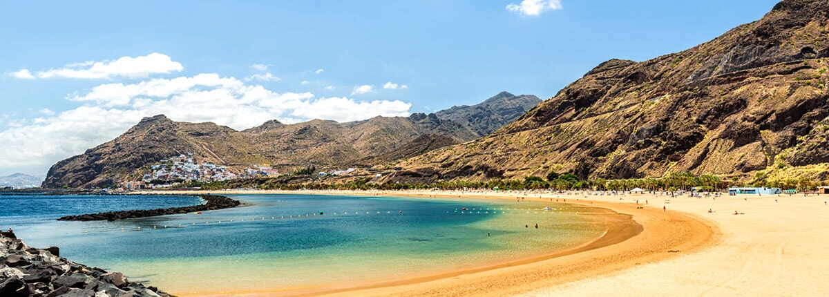 guests relax on the beach surrounded by mountains