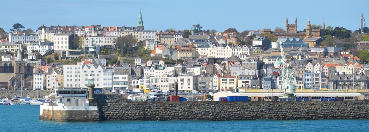 multistory buildings lines the coast of st peter port