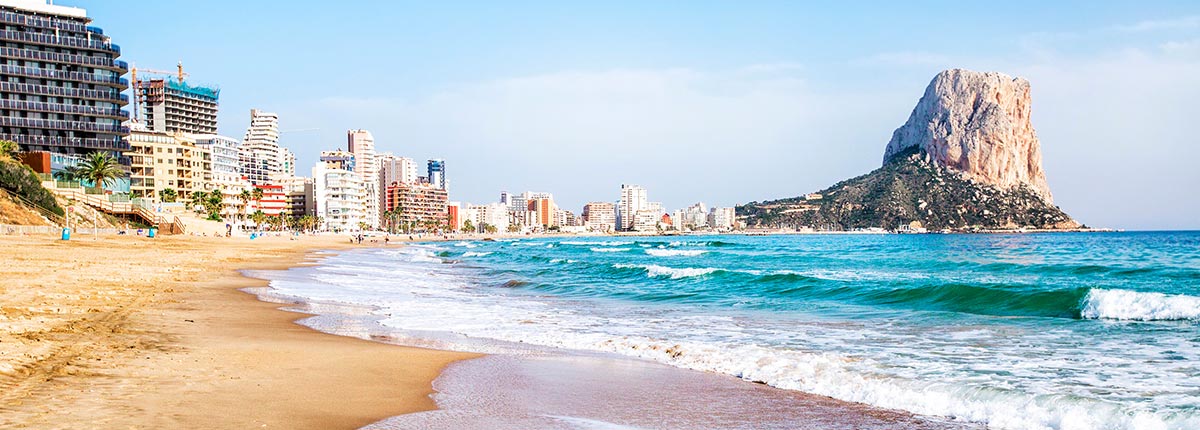 view of a beach and the Penon de Ifach mountain