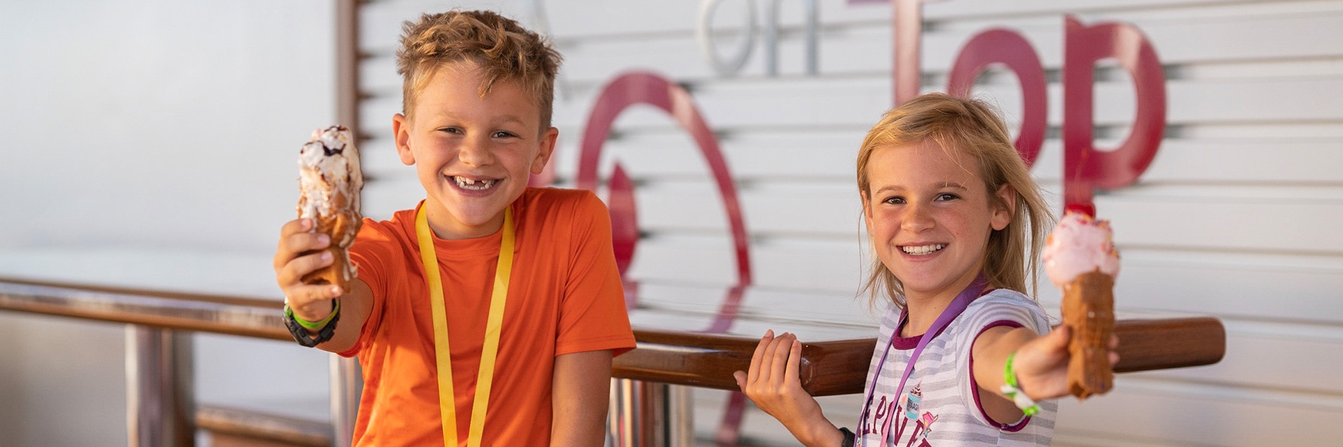 two kids holding up ice cream cones onboard a carnival cruise ship