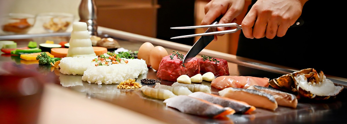 a chef prepares a meal at bonsai teppanyaki