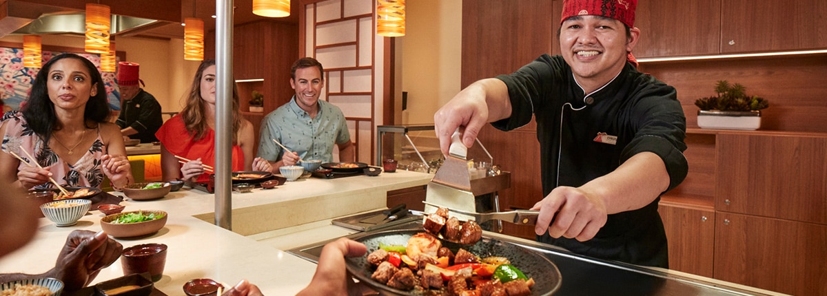 a chef smiles as he prepares a meal at bonsai tepanyaki