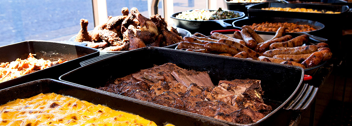 assorted selection of championship pork butt, smoked andouille sausage, blue ribbon chicken, mac daddy mac n cheese, and molasses baked beans