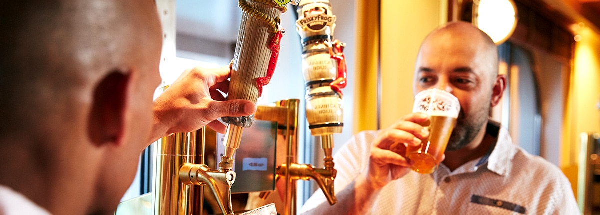 two men pouring their own beers at the beer station at red frog pub and brewery