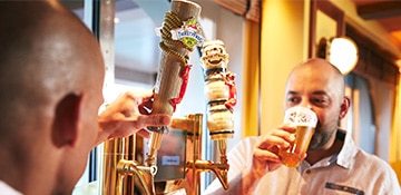 two men pouring their own beers at the beer station at red frog pub and brewery