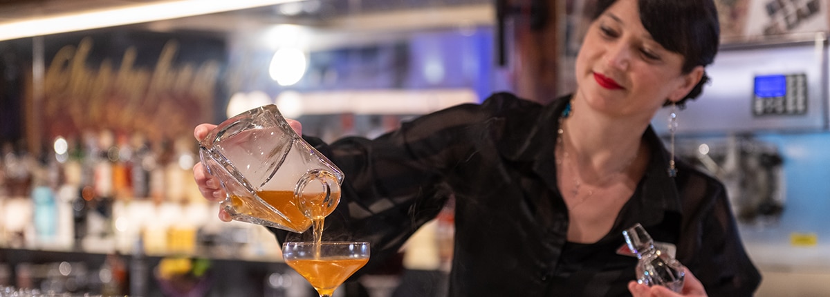 bartender serving a cocktail at the fortune teller bar on a carnival cruise ship