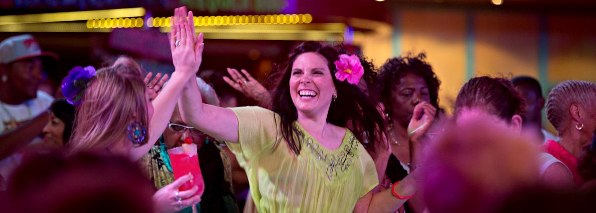 two carnival cruise vacationers high fiving each other at the mega deck party