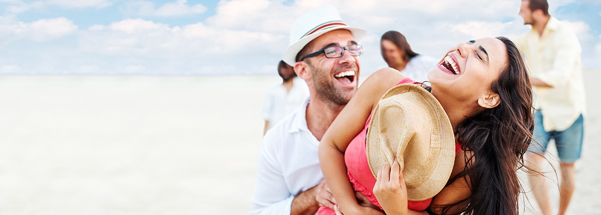 A COUPLE ON THE BEACH LAUGHING